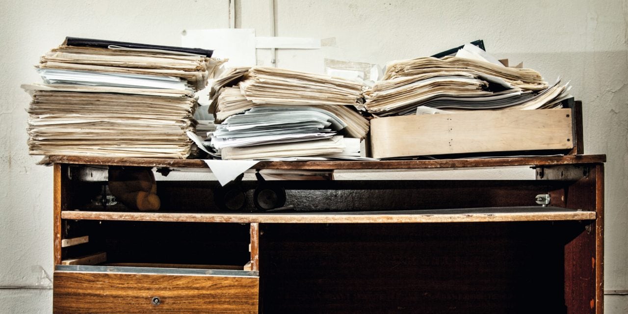 Messy workplace with stack of paper